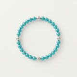 Bracelet perles d'eau douce bleu turquoise et billes argent 925 sur fond neutre.