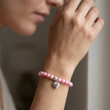 Bracelet perles d'eau douce roses en argent 925 avec charm cœur, porté au poignet.