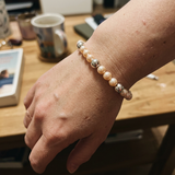 Bracelet en argent 925 et perles d'eau douce roses porté au poignet.