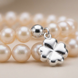 Gros plan bracelet double rang perles d'eau douce roses avec charm trèfle argent 925.