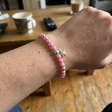 Bracelet perles d'eau douce roses fushia argent 925 avec charm étoile, porté au poignet.