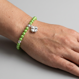 Bracelet perles d'eau douce vertes tonic argent 925 avec charm trèfle porté au poignet.
