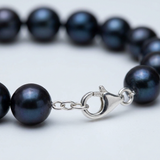 Bracelet perles noires 8/9 mm argent 925 avec fermoir mousqueton argenté, gros plan.