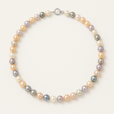 Le Perlinea Collier NOELYSE présente des perles de culture multicolores de 6/7 mm en blanc, pêche et lavande avec un fermoir en argent 925, élégamment disposées en cercle sur un fond blanc.
