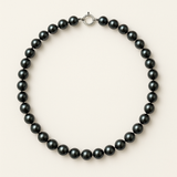 Collier de perles noires 7/8 mm sur fond neutre avec fermoir en or blanc 9 carats.