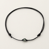Collier ras-le-cou en coton ciré noir avec une perle de Tahiti grise, réglable par nœuds coulissants.