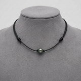 Collier ras le cou en coton ciré noir avec une perle de Tahiti verte sur mannequin.