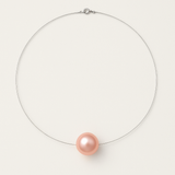 Le Perlinea Collier SOFIA | Perle Rose Naturel présente une seule perle de culture ronde rose naturelle sur un cordon fin, presque invisible, avec un fermoir en argent 925, élégamment mis en valeur sur un fond blanc.