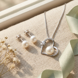 Collier et boucles d'oreilles à perles blanches sur chaîne argentée, pendentif cœur avec cristal.